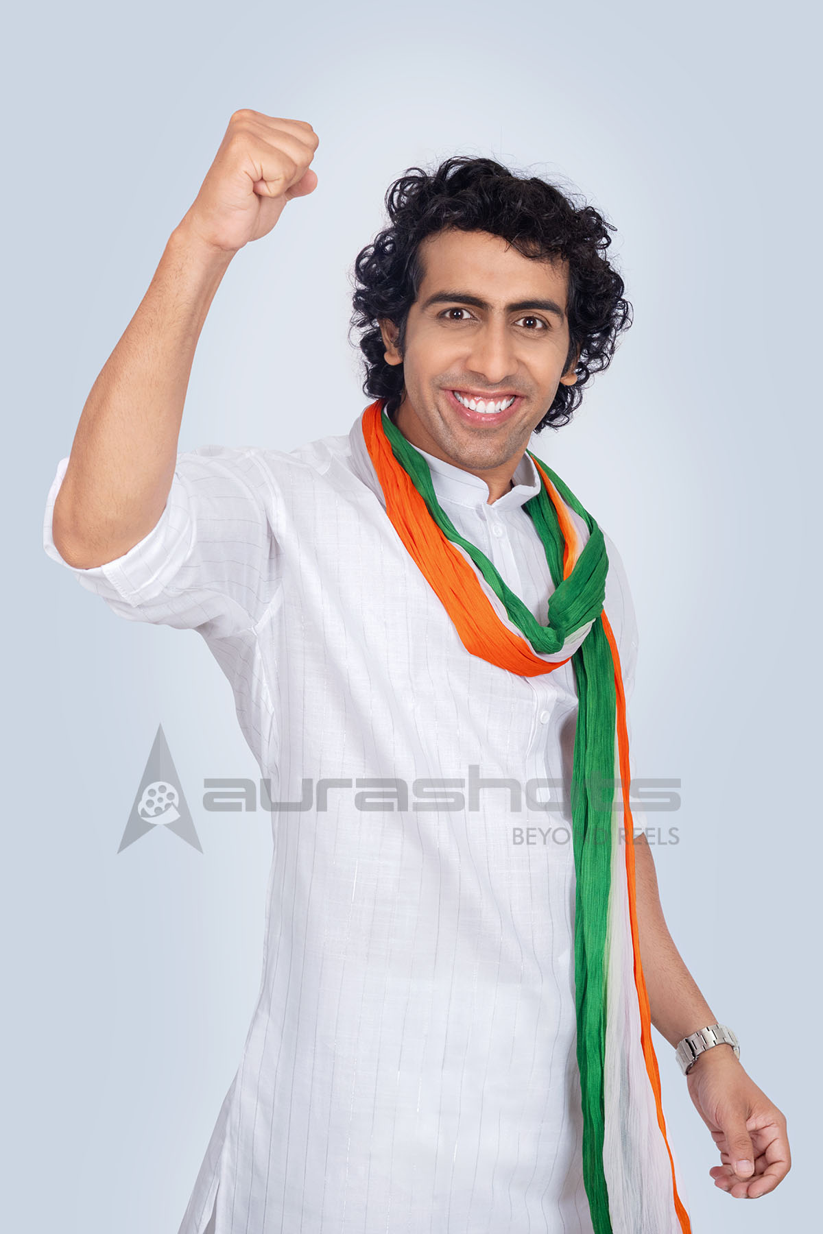 Indian man cheering with raised fist wearing tricolor scarf