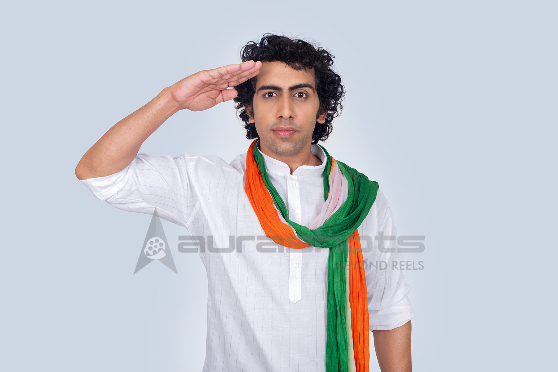 Indian man giving salute wearing tricolor scarf symbolizing patriotism