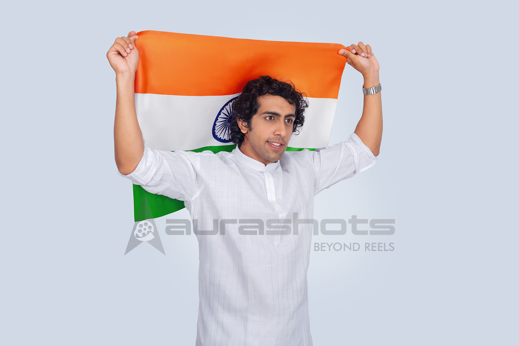 Indian man posing with national flag behind him