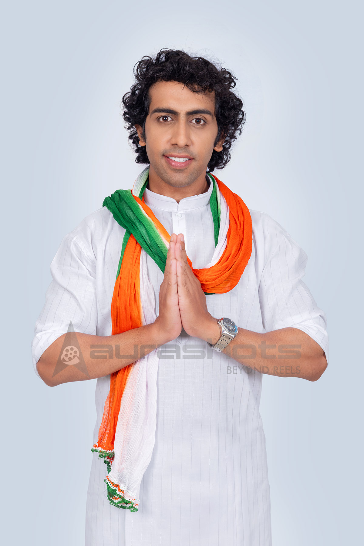 Indian man with a tricolor scarf doing namaste