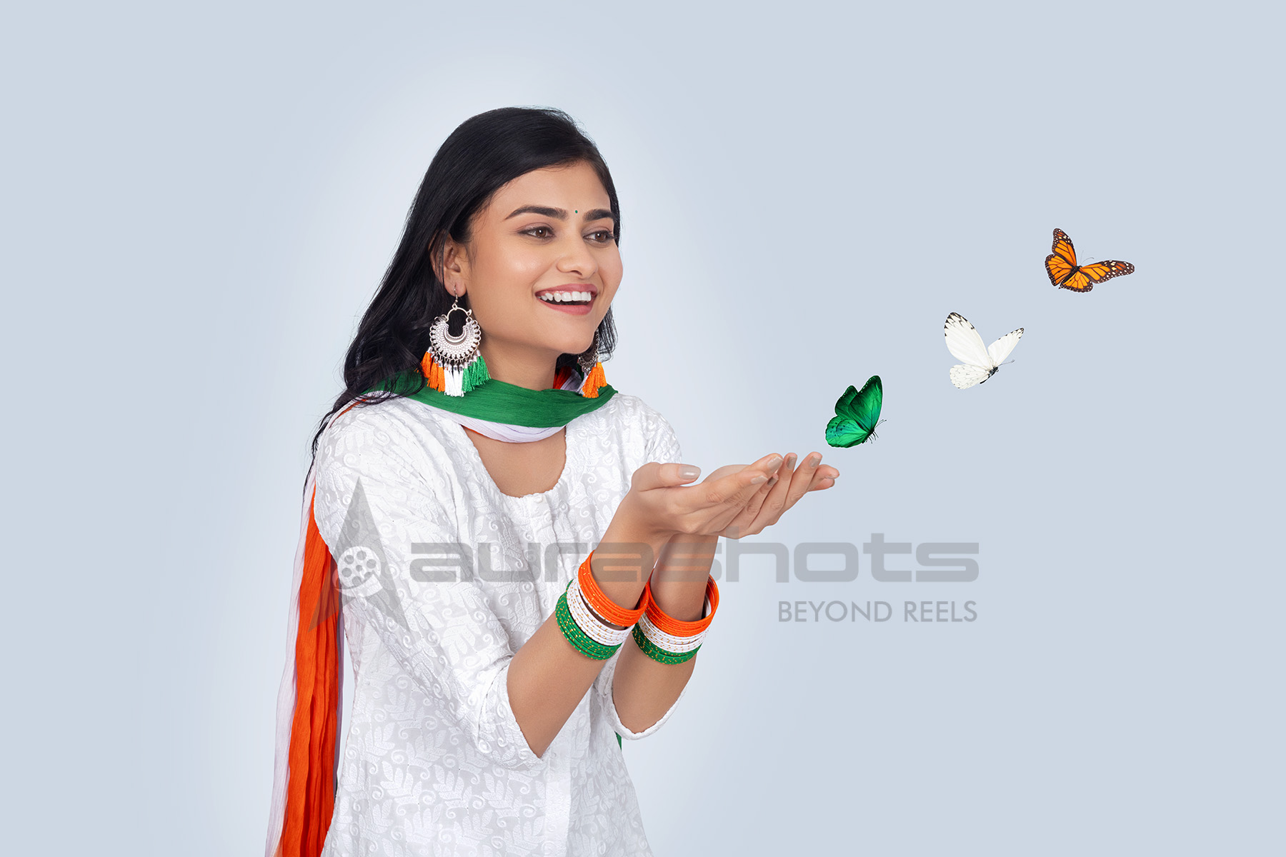 Indian woman releasing butterfly with tricolour accessories