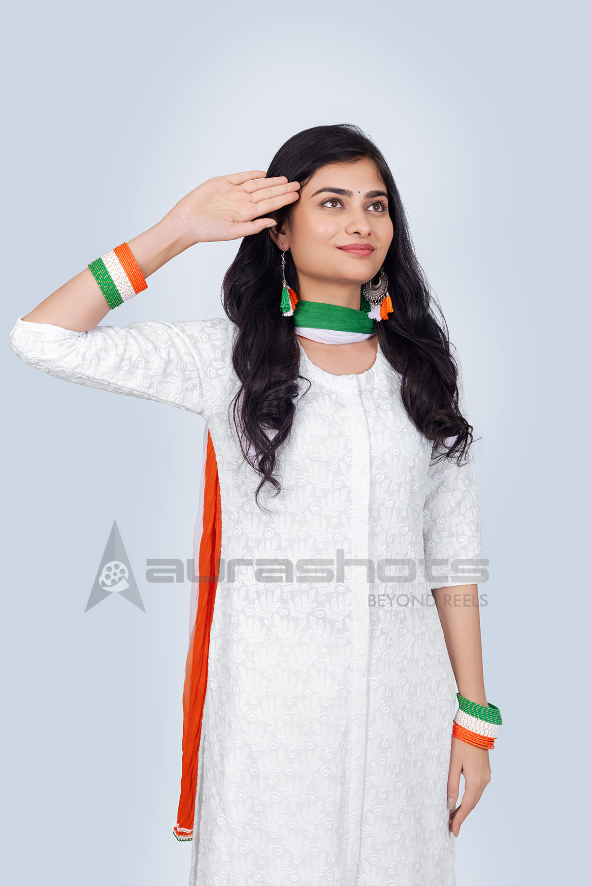Indian woman saluting in white dress with tricolor scarf