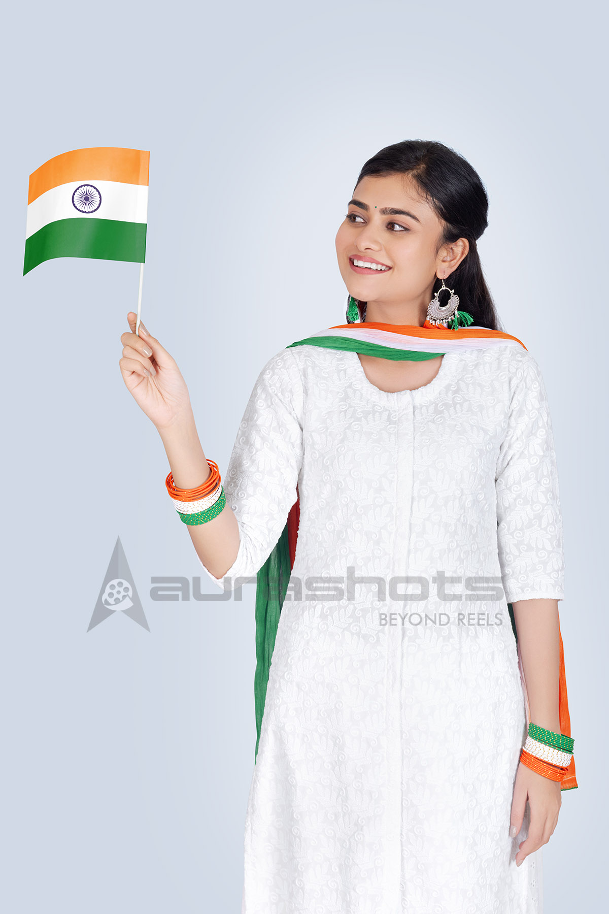 Smiling Indian woman holding mini national flag