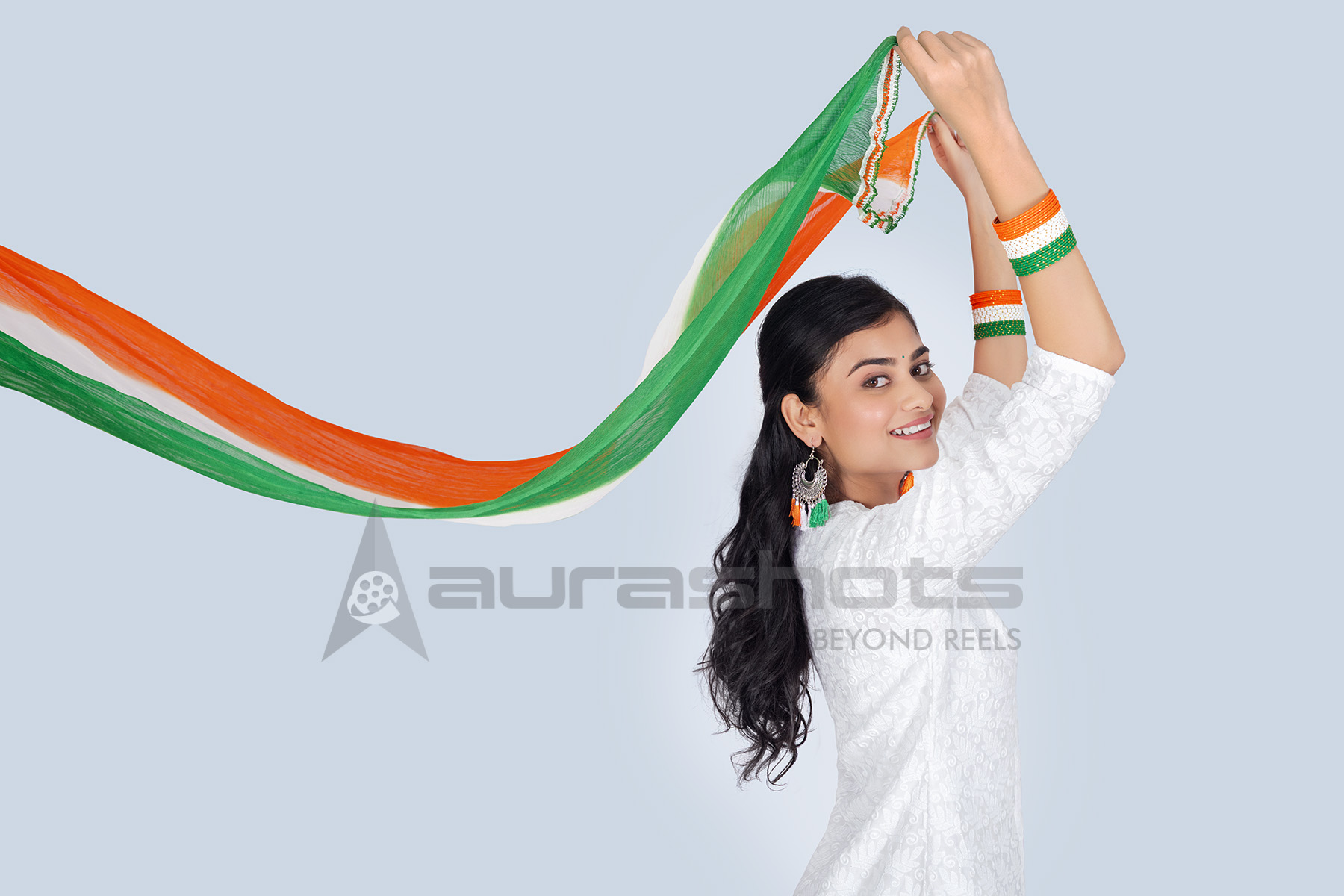 Indian woman holding flowing tricolor dupatta
