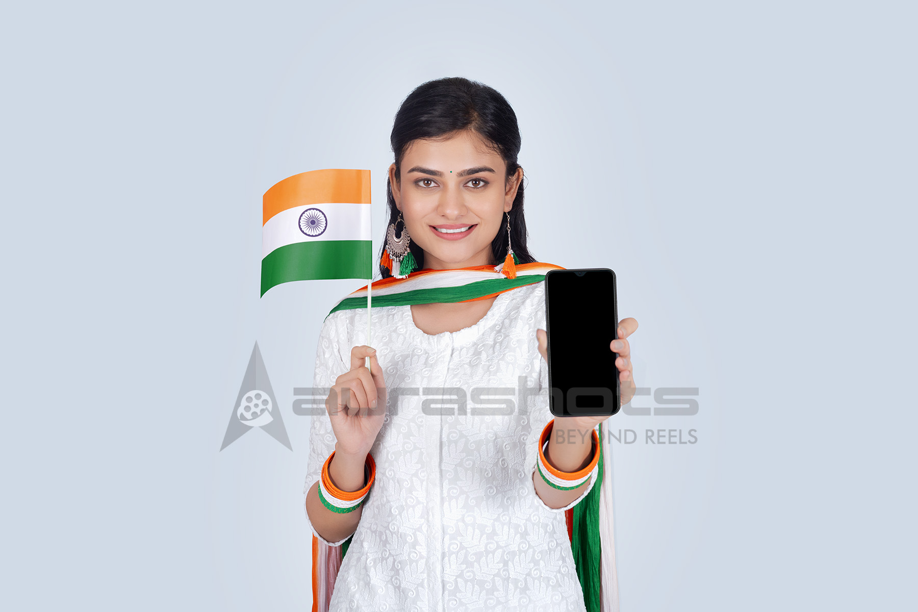 Indian woman holding flag and smartphone proudly