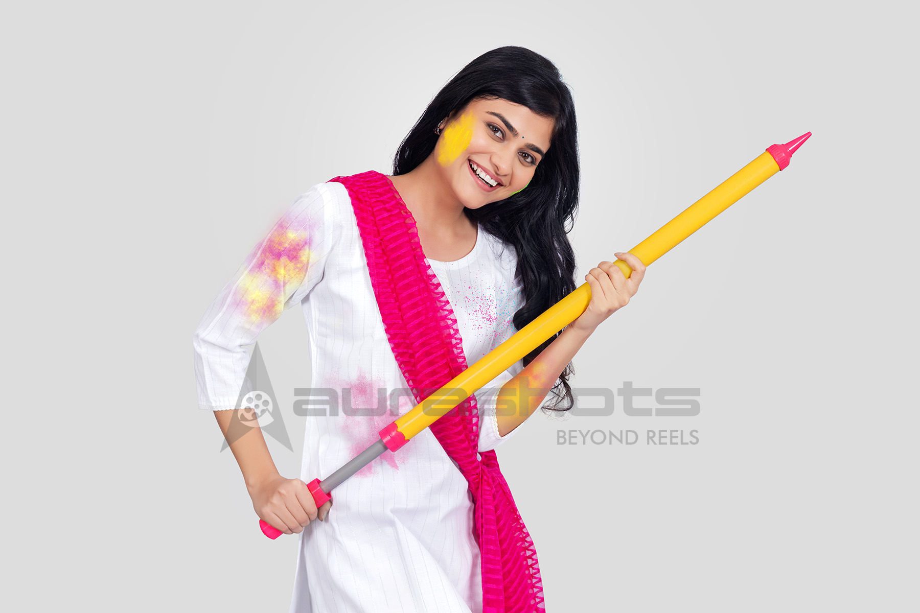 Indian woman playing Holi with colorful pichkari