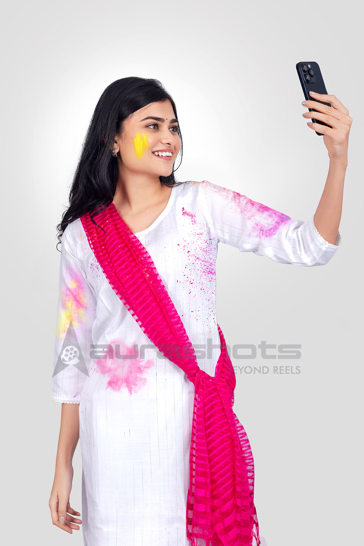 Indian woman enjoying Holi and taking selfie