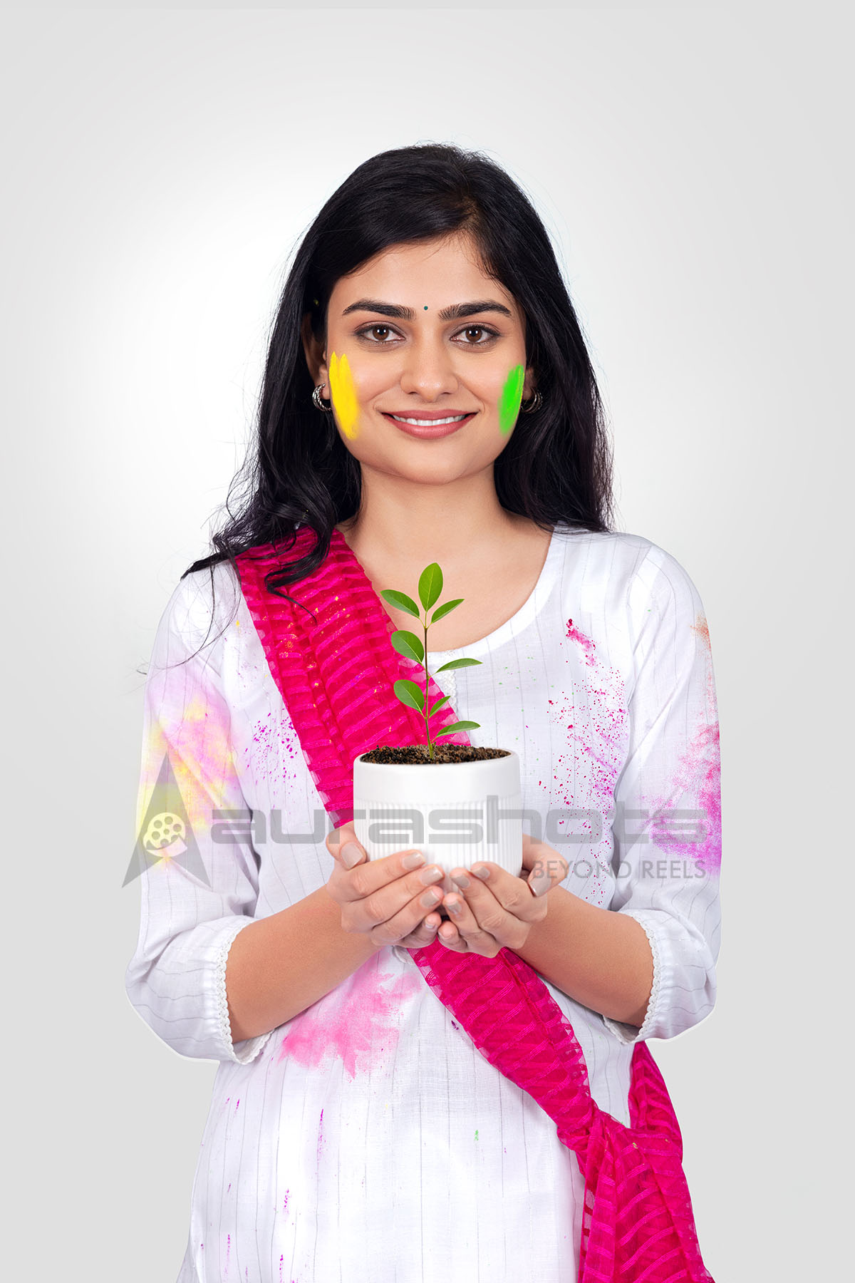 Indian woman celebrating Holi holding a flower pot
