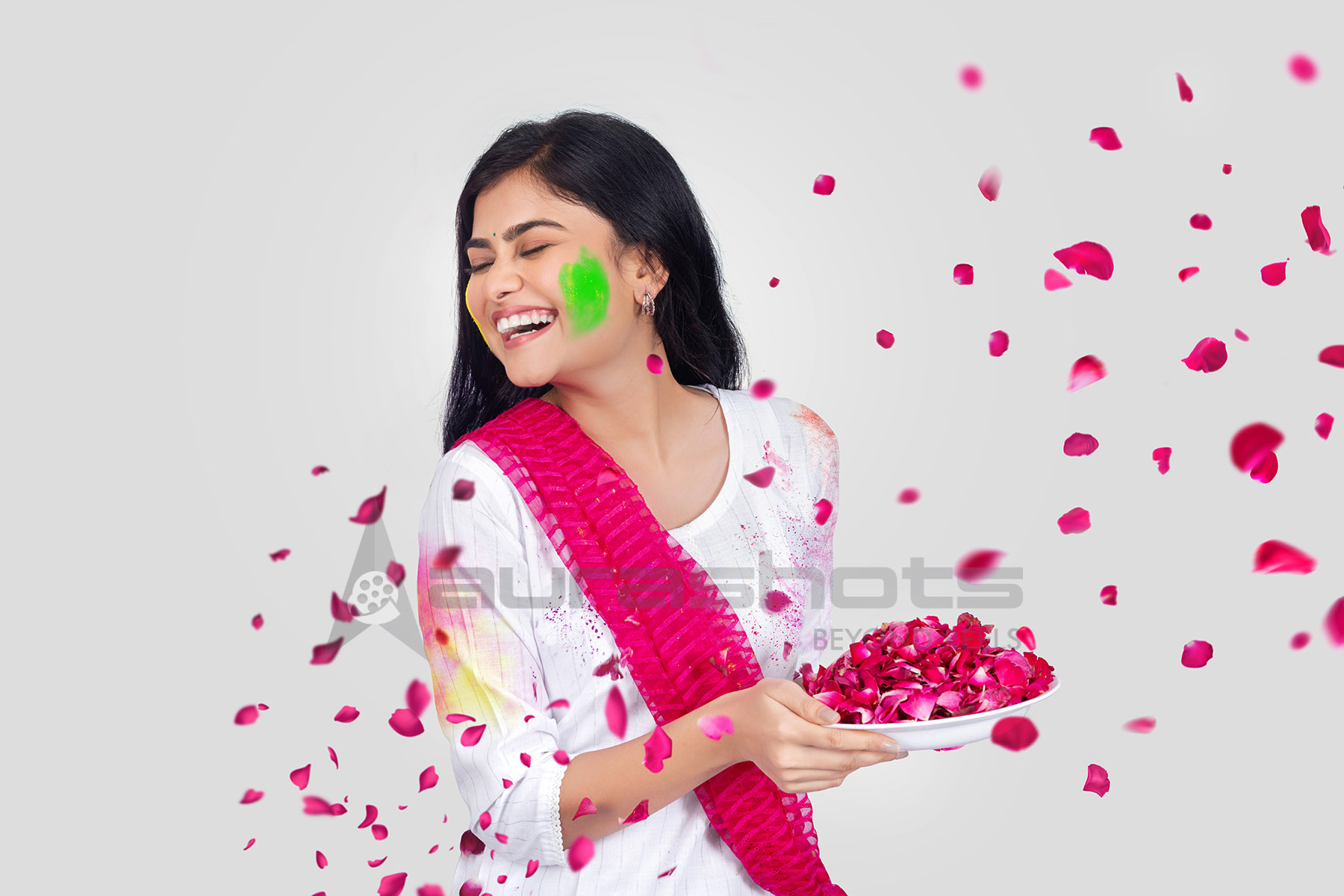Indian woman playing with rose petals during Holi festival