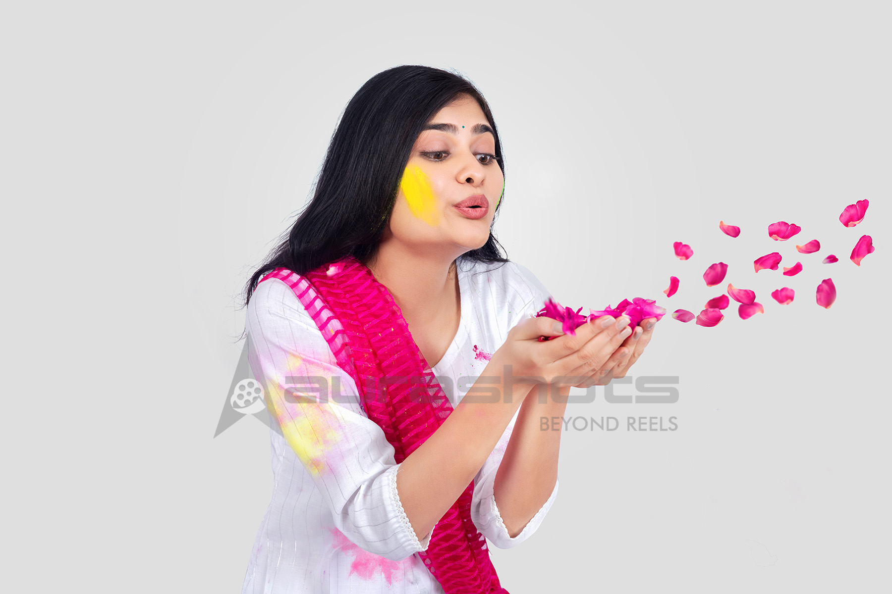 Woman blowing rose petals in a festive celebration