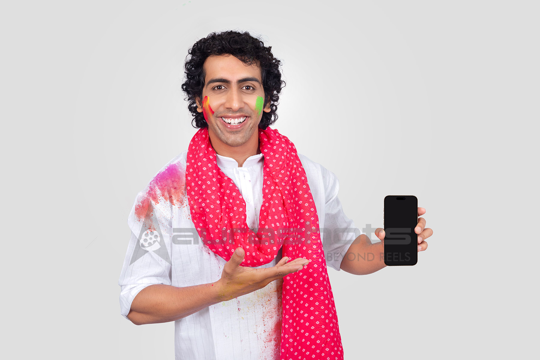 Indian man displaying smartphone with festive smile