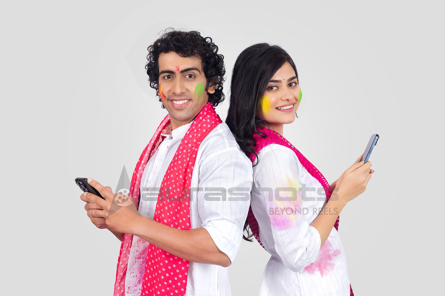 Couple using mobile phones during Holi celebration