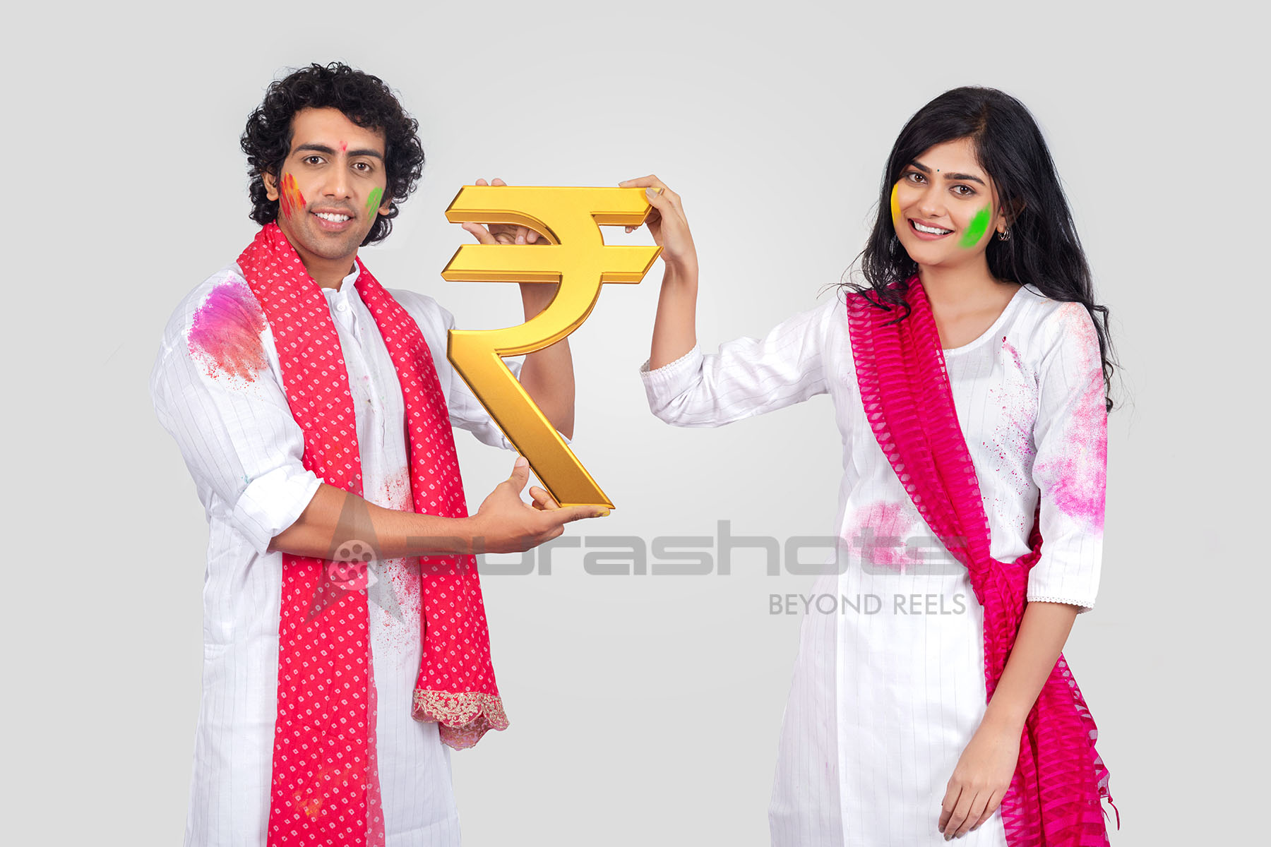Couple holding Indian rupee symbol during festive celebration
