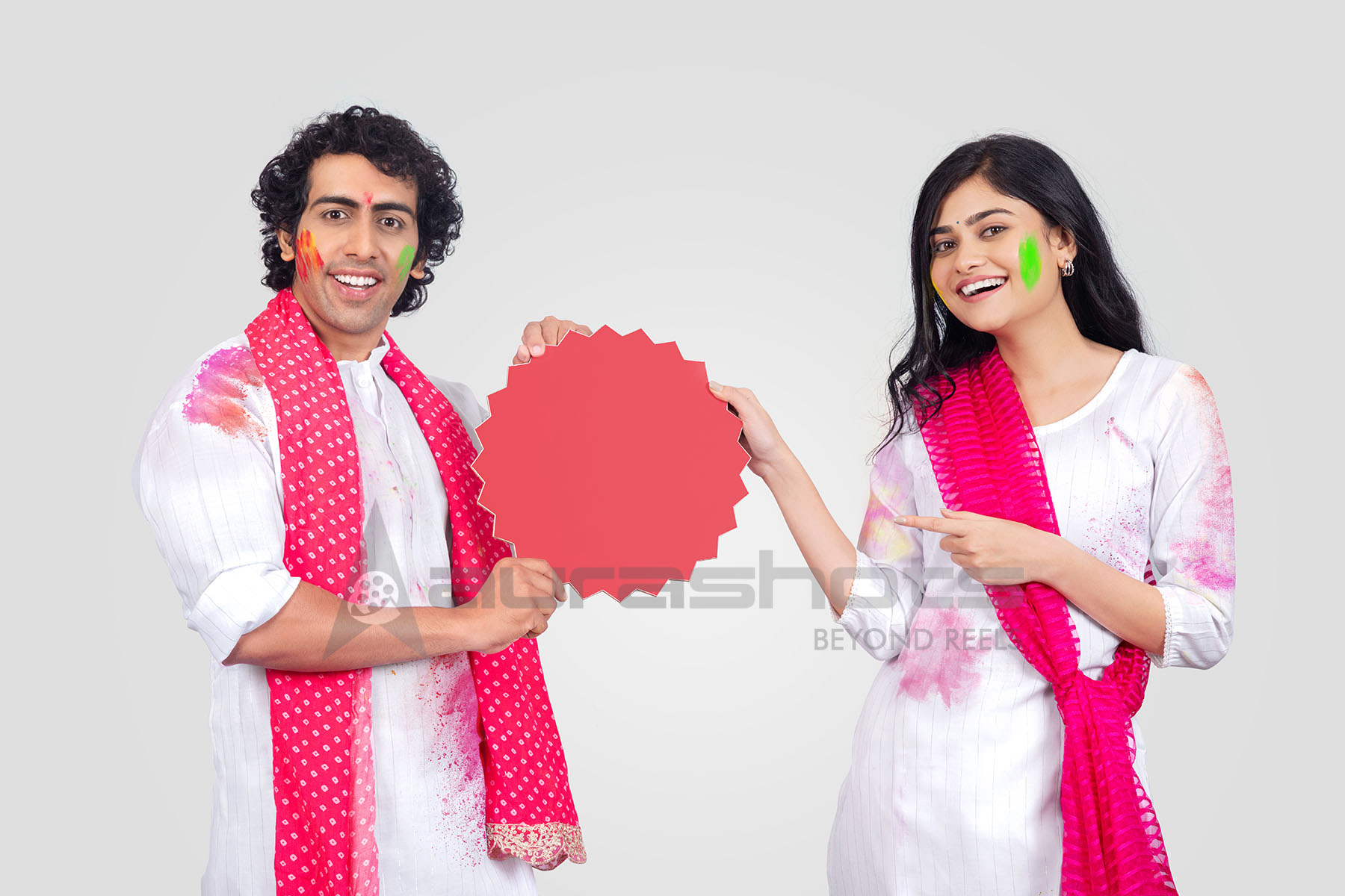 Couple holding round cutout for Holi promotion