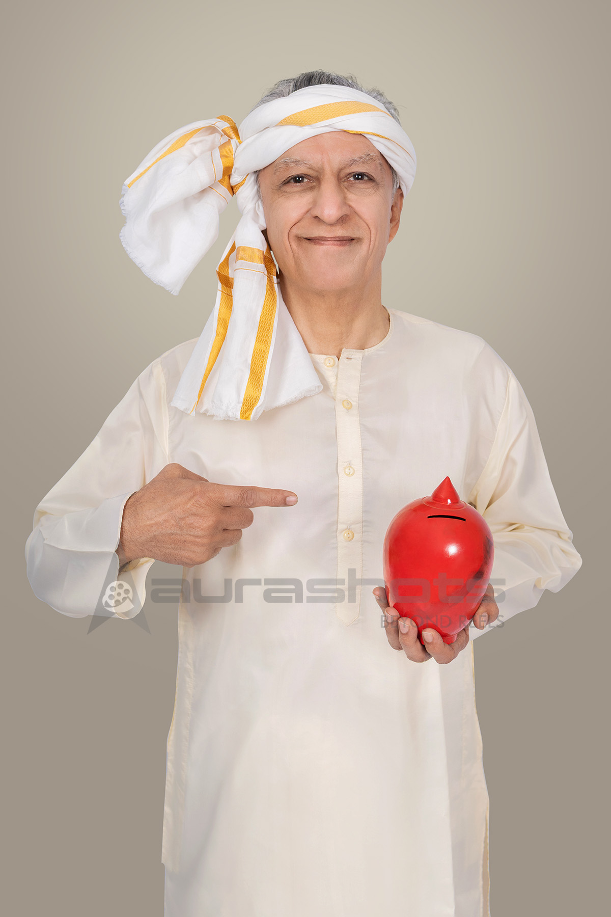 Elderly rural man holding piggy bank