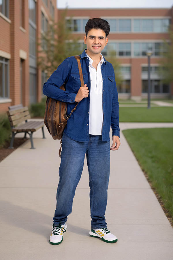 Full length portrait of Indian student with backpack on campus