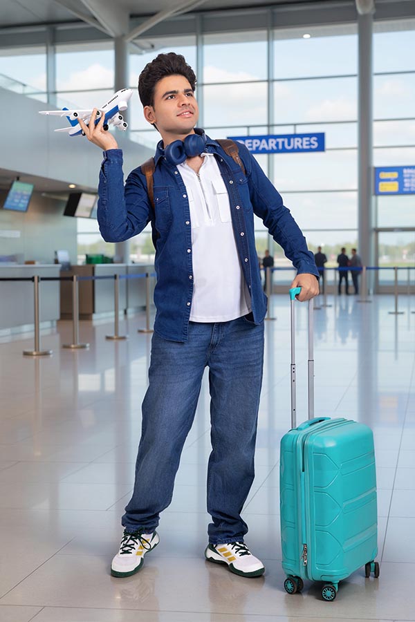 Young Indian traveler student with suitcase at airport terminal