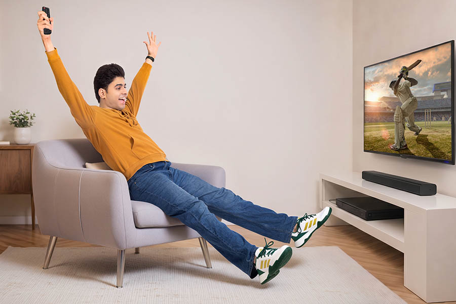Excited Indian teenager celebrating cricket match while watching television at home