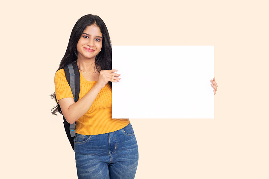 Indian teenage girl holding blank placard for advertisement