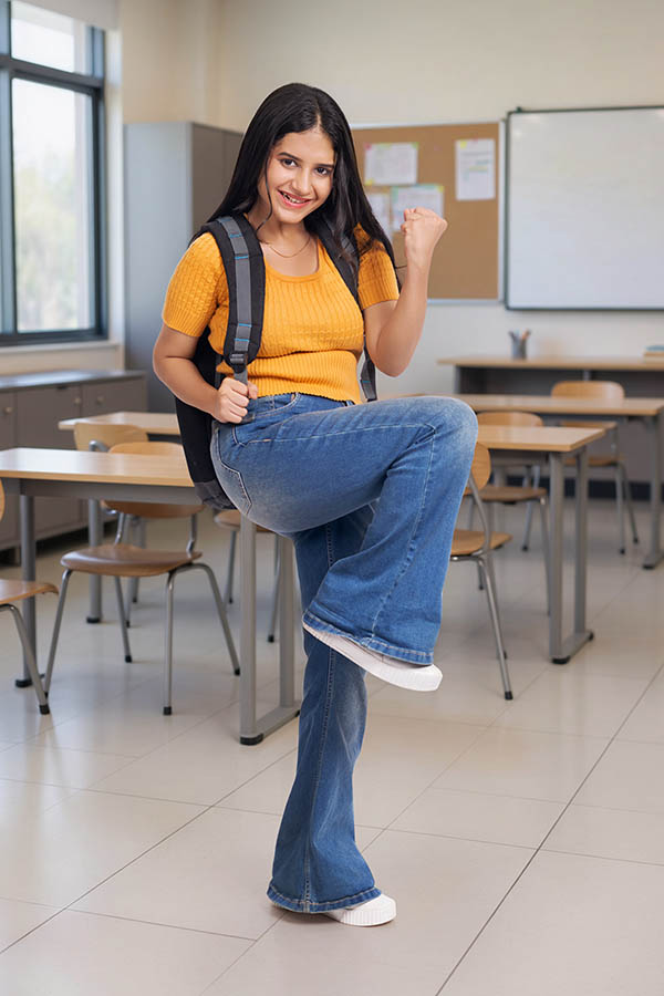 Excited Indian college girl celebrating success inside classroom