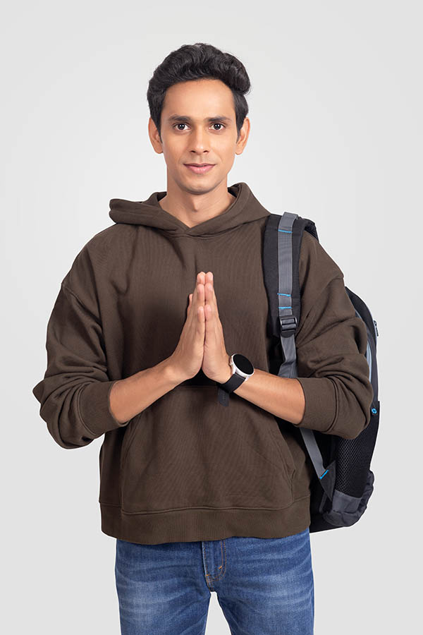 Young Indian male student greeting with namaste gesture in studio