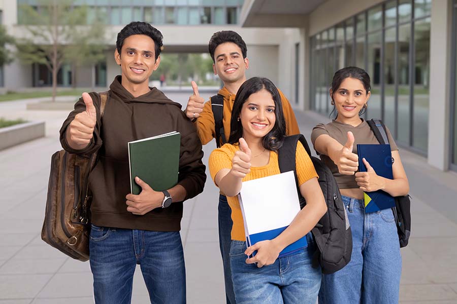 Group of Indian college students showing thumbs up outdoors