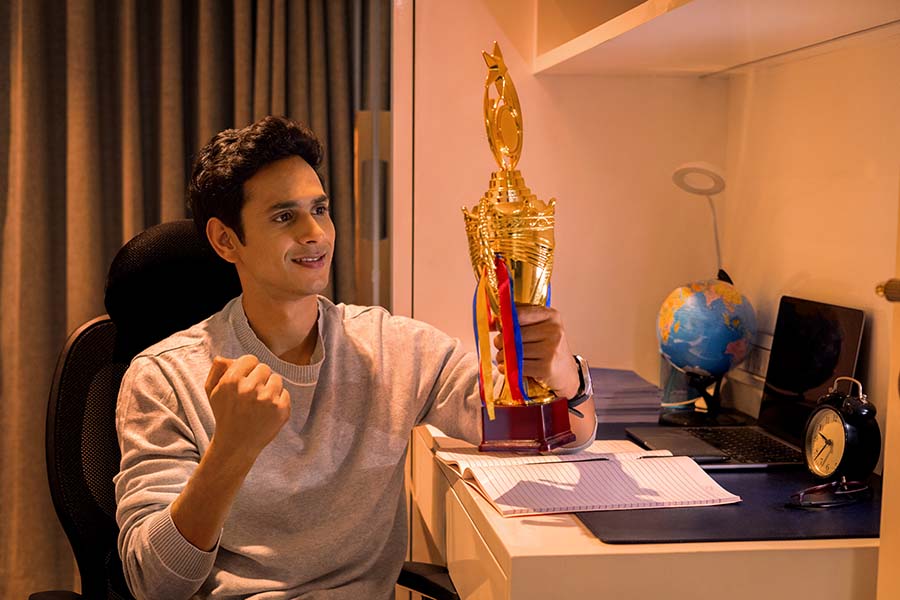 Indian student holding trophy after academic achievement