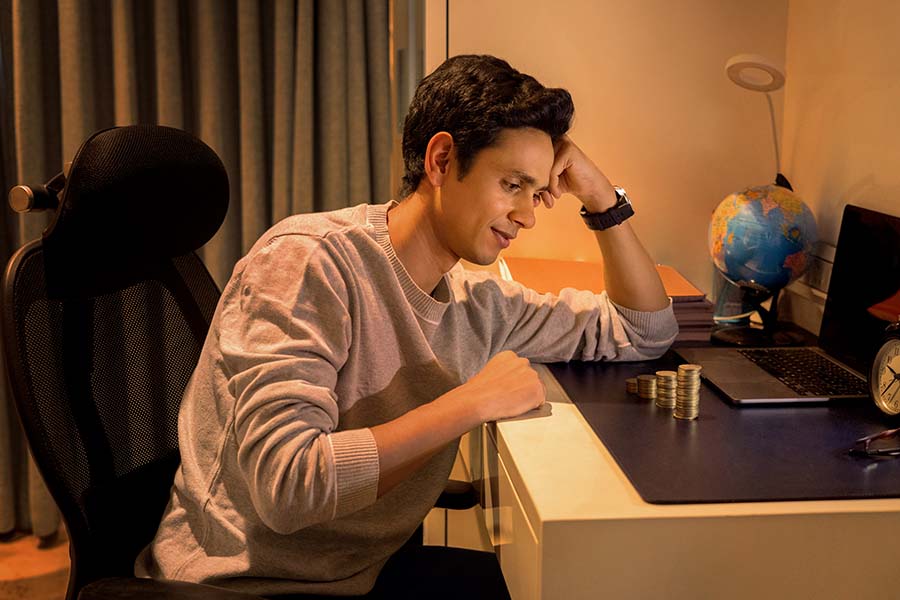 Worried Indian student thinking about savings and expenses