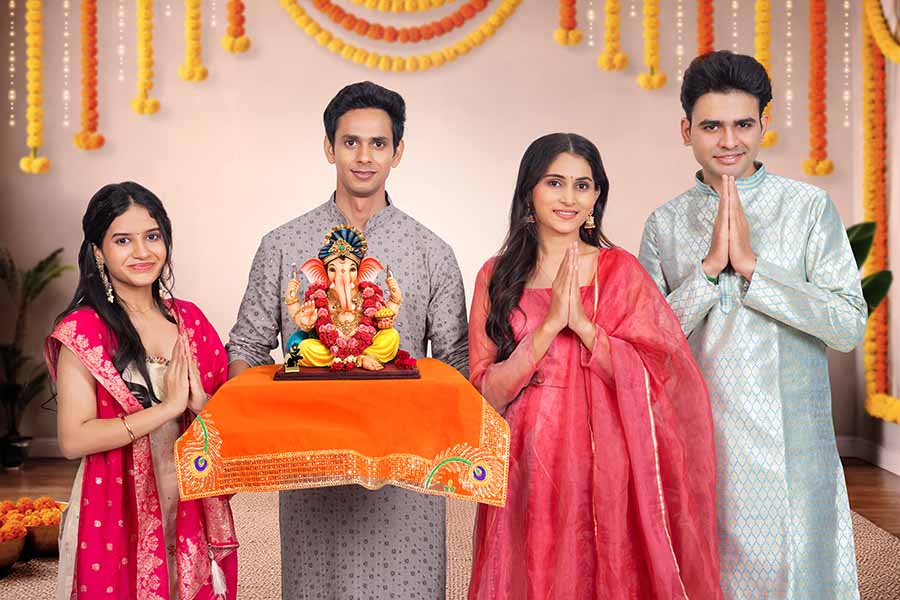 Family praying to ganesha idol during ganesh chaturthi