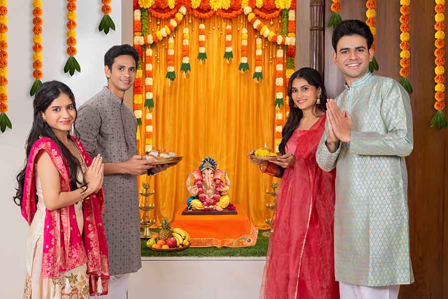 Indian family performing aarti infront of Lord Ganesha during festival