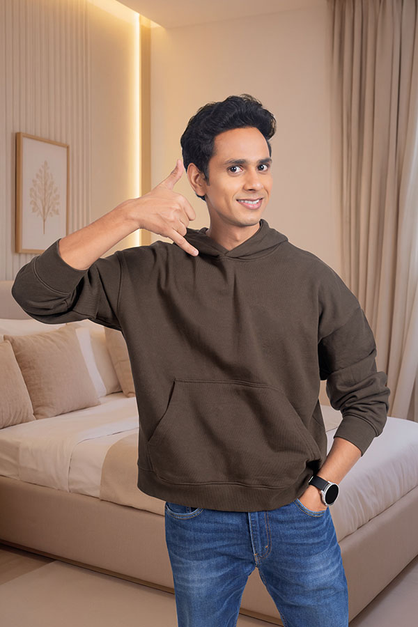 Young Indian man making call me gesture in hotel room