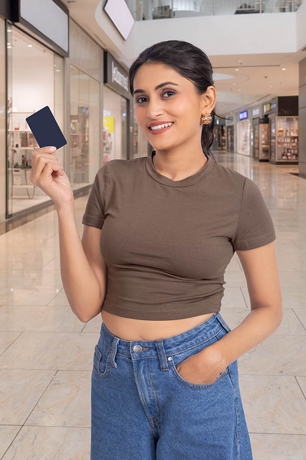 Young Indian woman displaying payment card in shopping mall