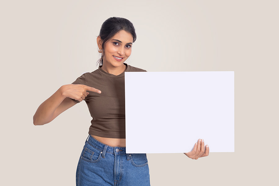 Indian woman pointing at blank signboard for advertisement message