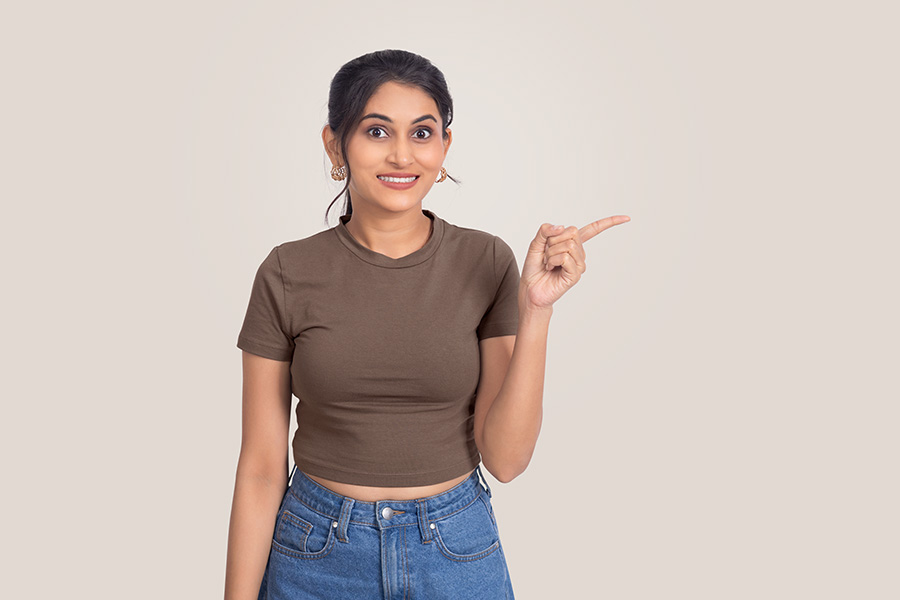 Excited Indian woman pointing towards promotional copy space