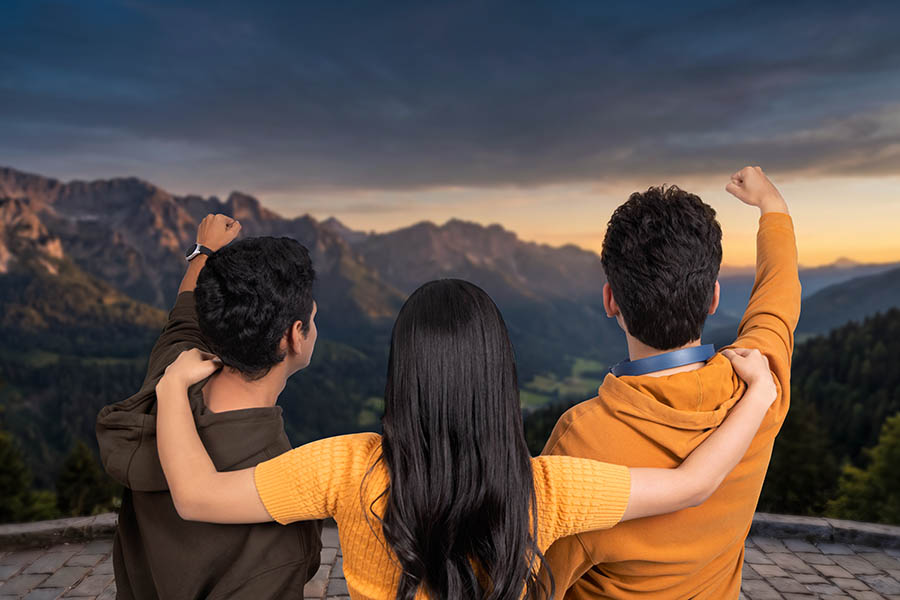Group of friends celebrating achievement while admiring mountain landscape