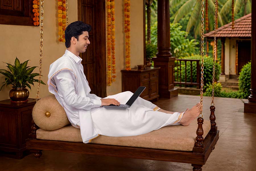 Relaxed Kerala man working remotely on laptop during festive season