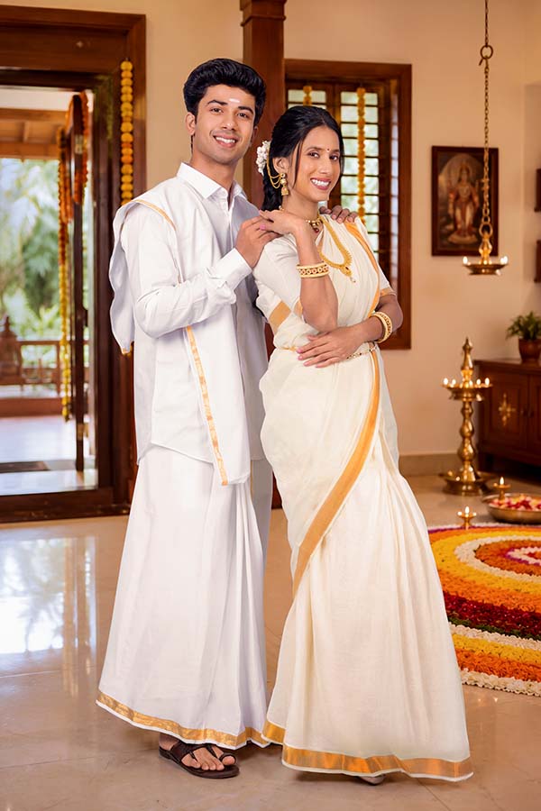 Elegant Indian couple posing together in traditional Kerala attire for Onam