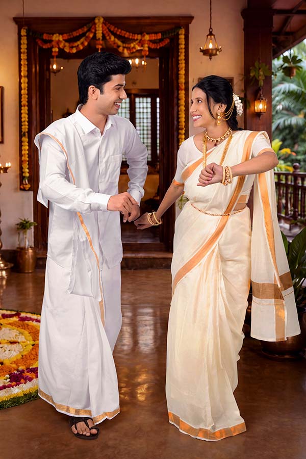 Indian couple enjoying traditional Onam dance at festive home