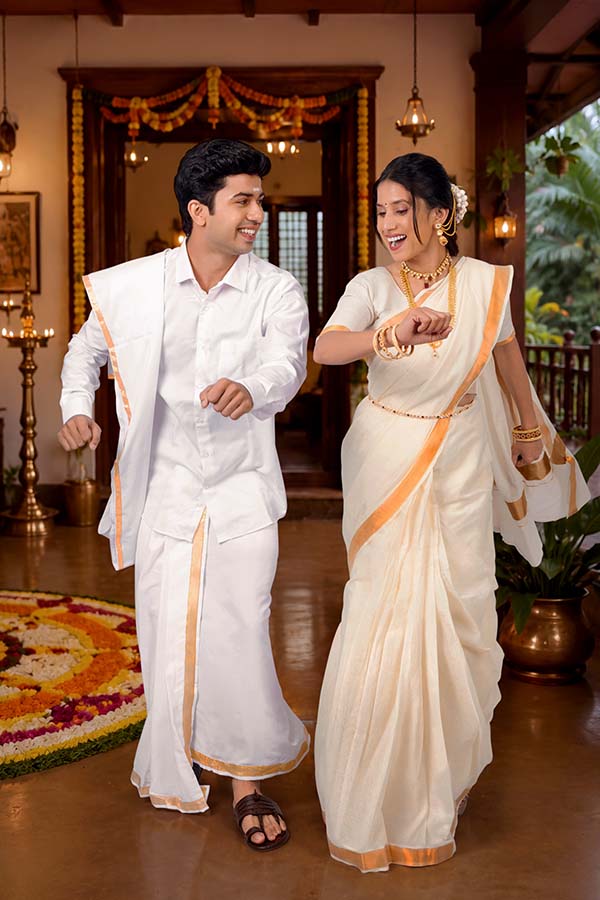 Happy Indian couple dancing together during Onam festival celebration