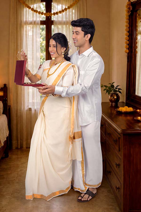 Kerala couple celebrating Onam with festive jewellery gift at home