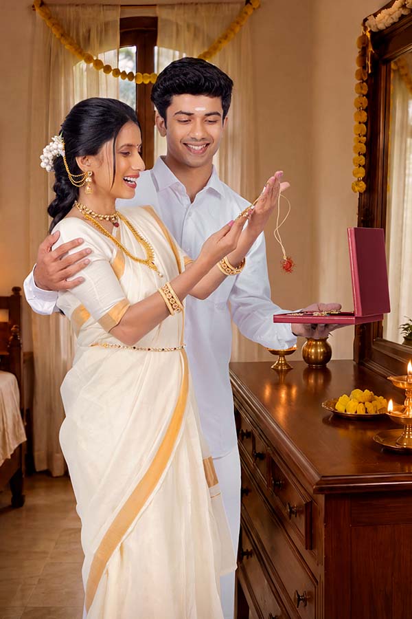 Indian husband presenting jewellery gift to wife during Onam