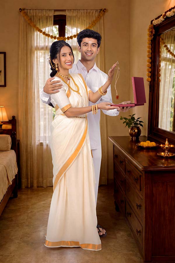 Happy Kerala couple presenting festive jewellery gift during Onam