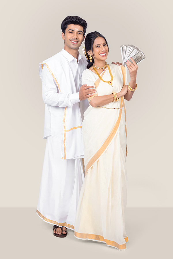 Indian couple displaying Indian currency notes during Onam celebration