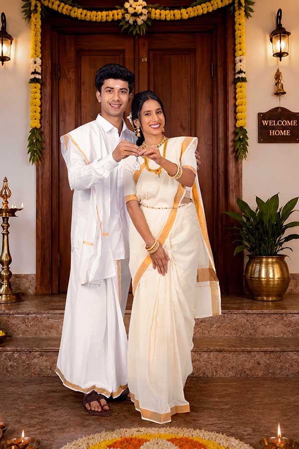Indian couple holding new home key during Onam celebration
