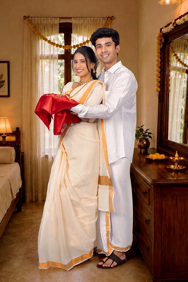 Indian couple presenting traditional gift wrapped in red silk cloth during Onam