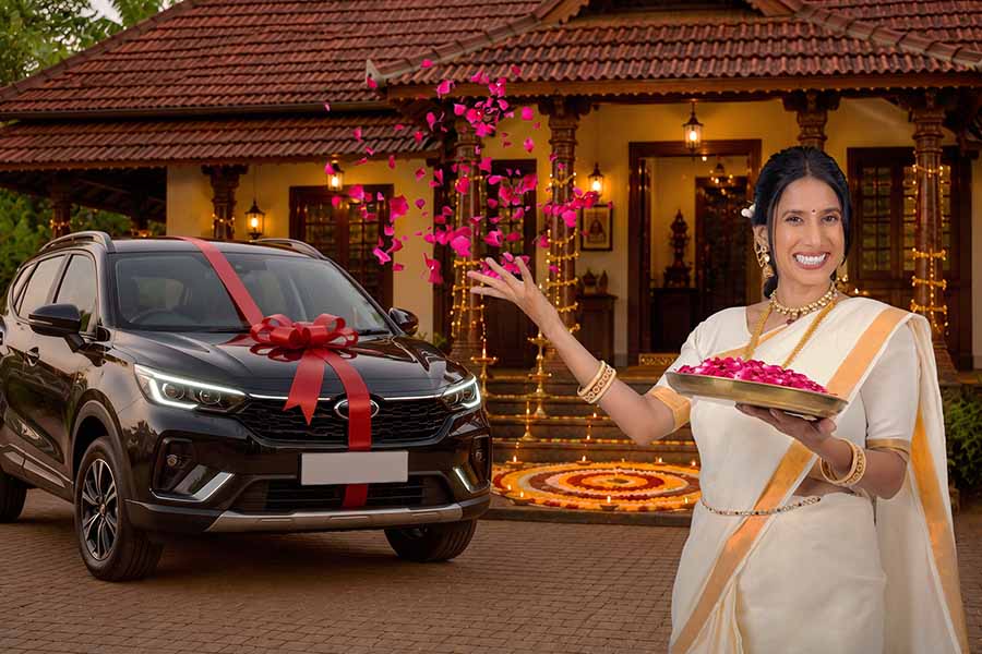 Woman welcoming new car with flower petals during Onam celebration