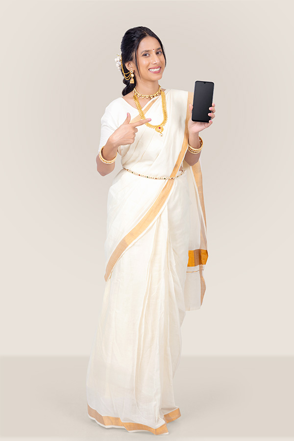 Woman pointing at blank smartphone screen in traditional Kerala attire