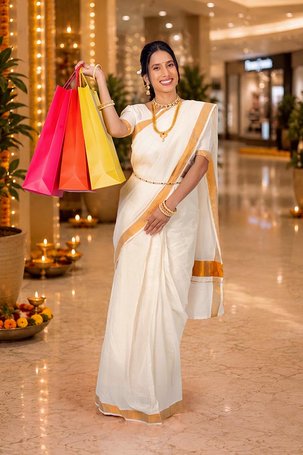 Woman holding festive shopping bags after Onam retail purchases