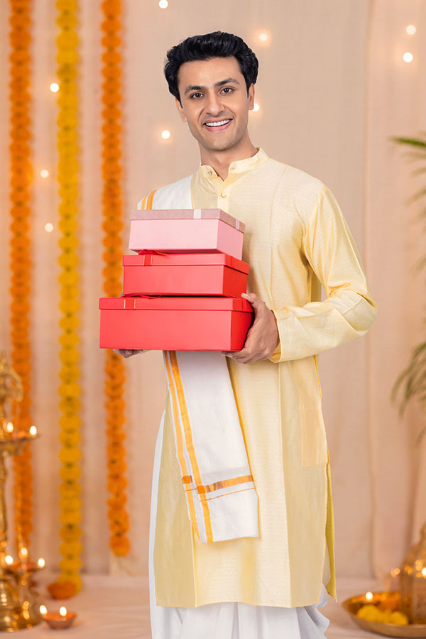 Indian man holding colourful gift boxes for Durga Puja celebration