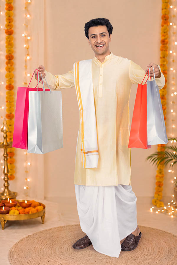 Indian man celebrating Durga Puja with shopping bags and festive decorations